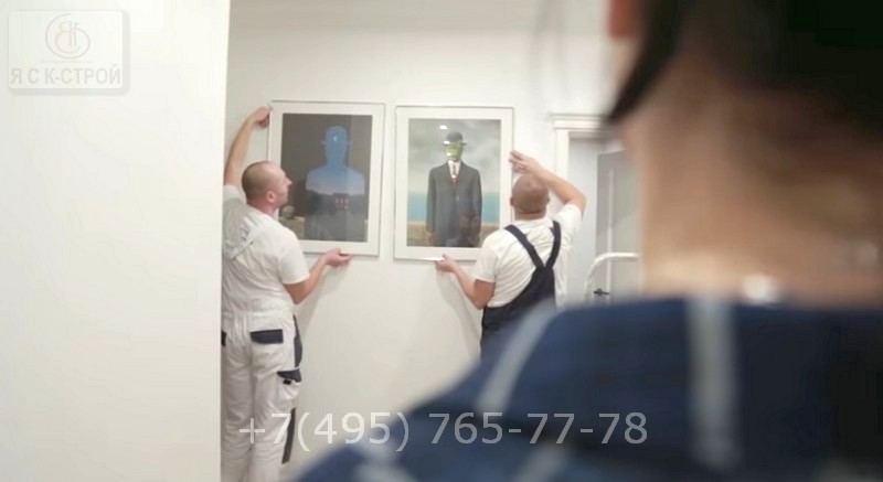 Специалисты на фото монтируют картины в коридоре после ремонта